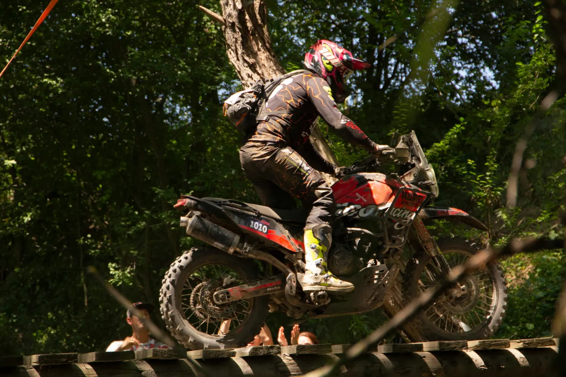Rider crossing a log obstacle in the woods